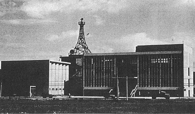 Fotografía en blanco y negro de la torre de TTV completada en 1962, con la torre de fotografía a la izquierda y la torre central a la derecha, con una torre de transmisión de televisión de hierro de pie detrás del centro