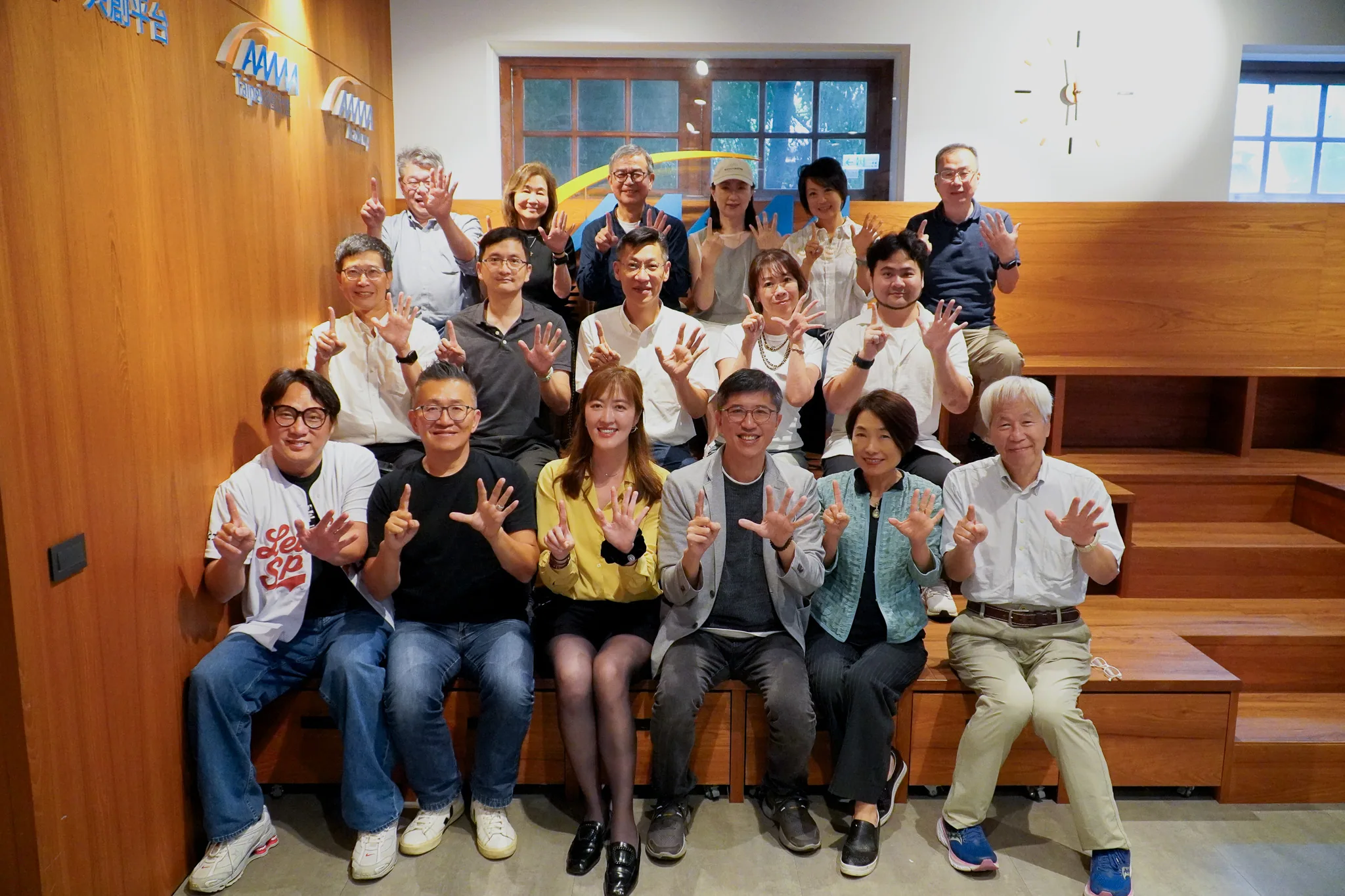 AAMA台北揺籃プログラム第15期選出起業家とメンター集合写真、室内の木製空間で「15」のジェスチャーを示す