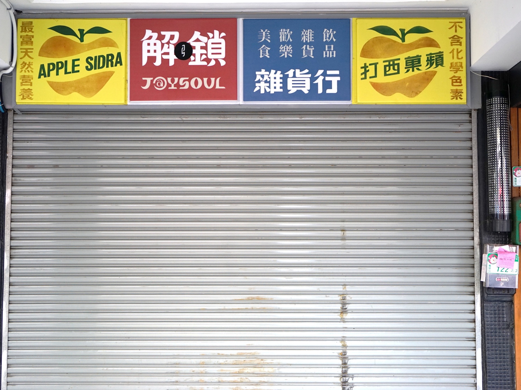 西門町商店的蘋果西打廣告燈箱,2025 年 2 月。金黃色澤的塑膠瓶裝產品仍是國民氣泡飲的視覺符號。