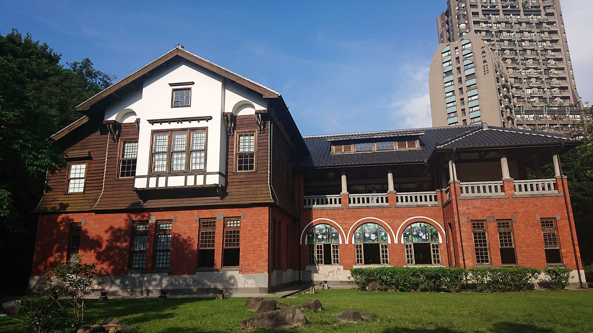 北投溫泉博物館(原 1913 北投公共浴場)二層紅磚仿英式建築外觀,含拱形迴廊與彩繪玻璃窗,由森山松之助設計