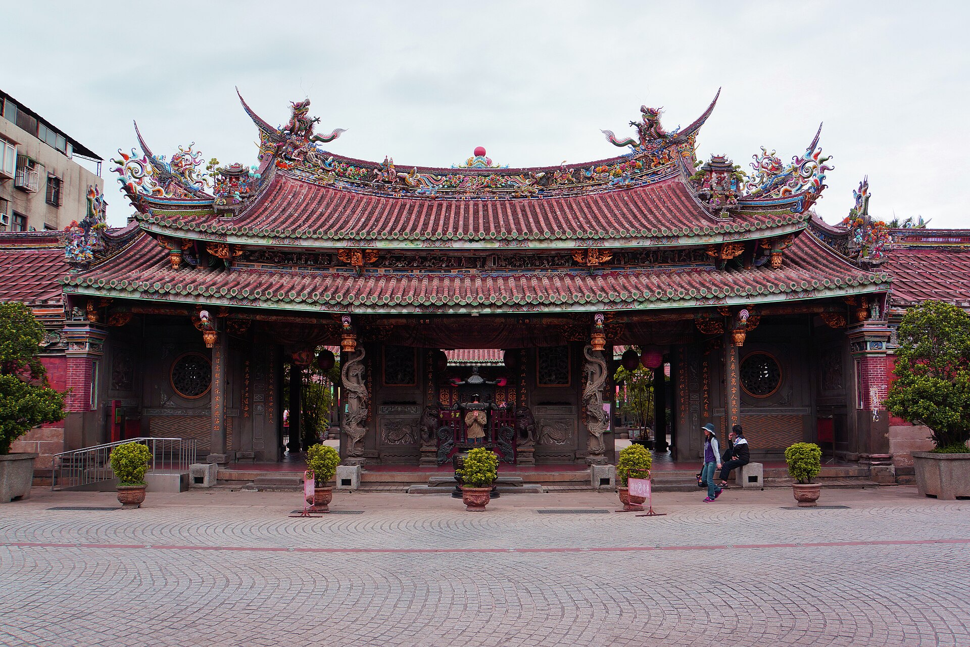 大龍峒保安宮正面建築全景,紅瓦黃簷三川殿與廣場。1742 年同安人迎請白礁慈濟宮保生大帝分靈來台草創,1830 年正式落成,1995-2002 廖武治主導自費修廟獲 UNESCO 亞太遺產獎。