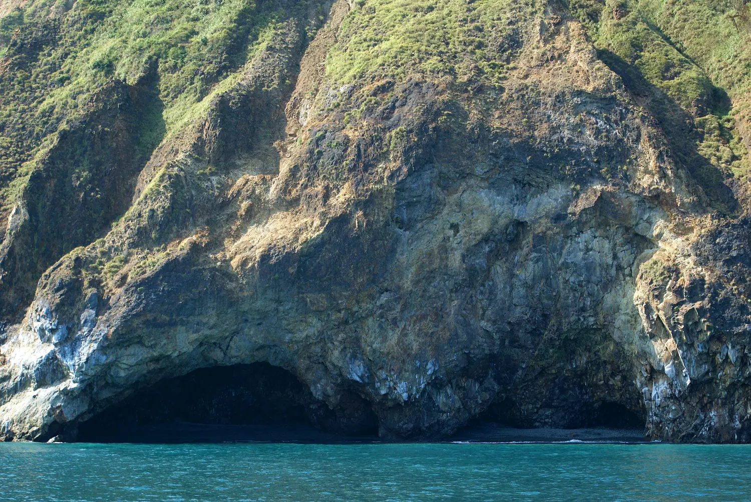 龜山島眼鏡洞，峭壁與海面交接處受海蝕形成的半圓形海蝕洞，形似眼鏡