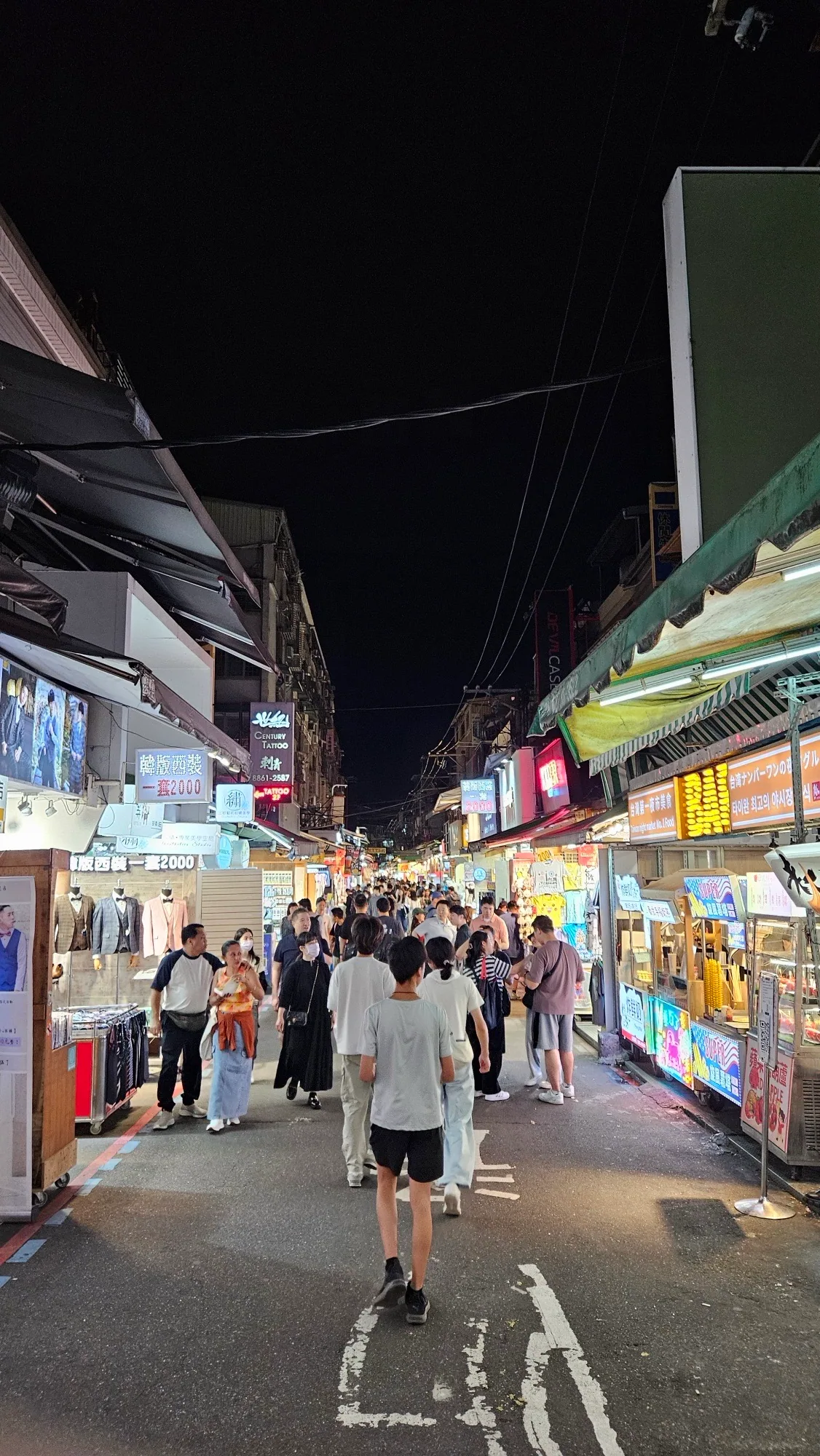 Night view of Da Dong Road, Shilin Night Market, June 2024, weekend evening crowds filling the alleys. 