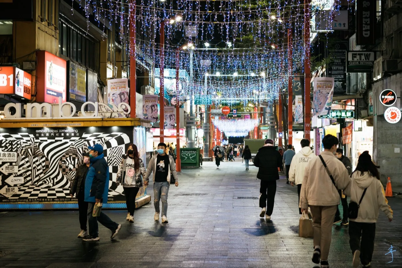 The Ximending pedestrian zone on a Christmas night, where crowds move under neon signs and holiday lights: the contemporary form of the same street in 2026