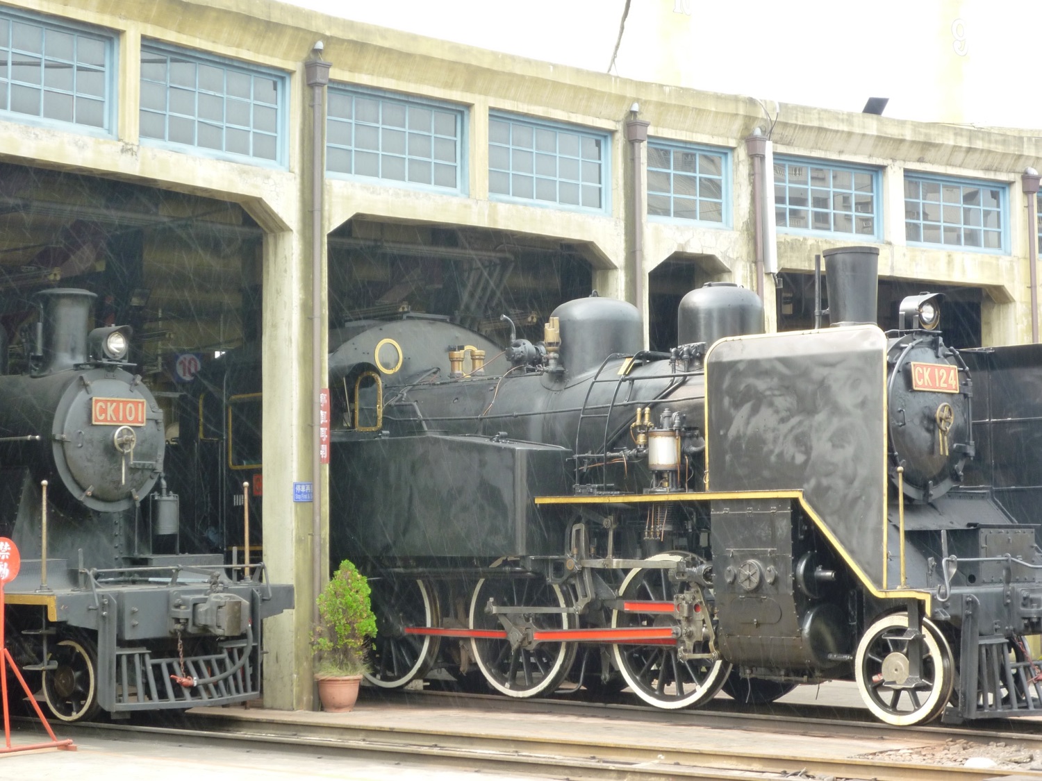 彰化扇形車庫保存的台鐵蒸汽機車群,2009 年攝,黑色機身、煙囪、駕駛室一字排開,是「黑頭仔」一詞的視覺出處