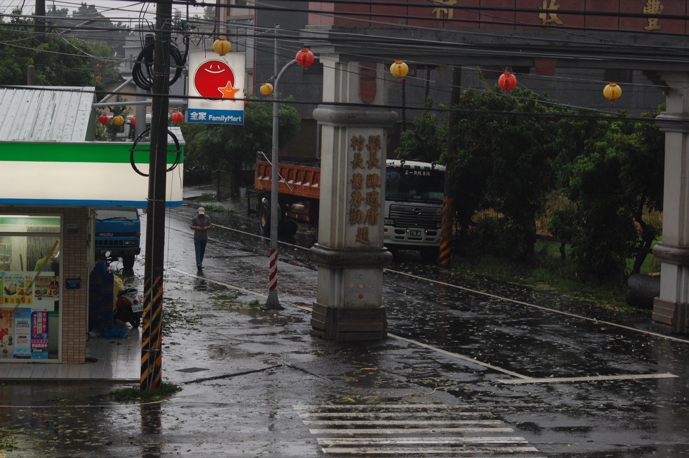 2009 年 8 月 9 日嘉義民雄一處村落在莫拉克豪雨後淹水,渾濁泥水淹過道路、漫進民宅一樓,遠處民眾涉水而行