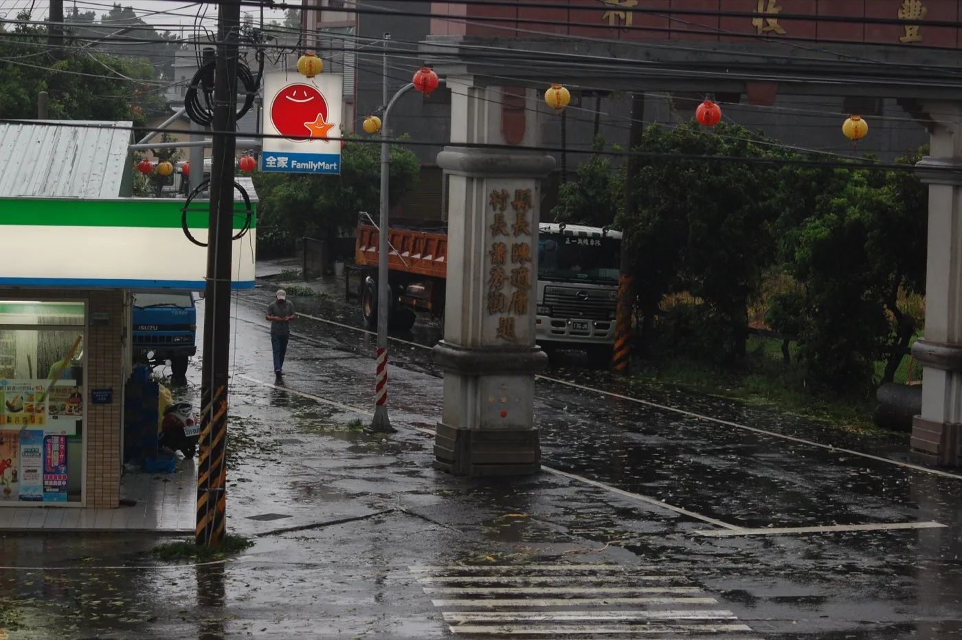 A village in Minxiong, Chiayi, flooded after Morakot's torrential rain on August 9, 2009; muddy water covers roads and enters the first floors of homes, while people wade through water in the distance