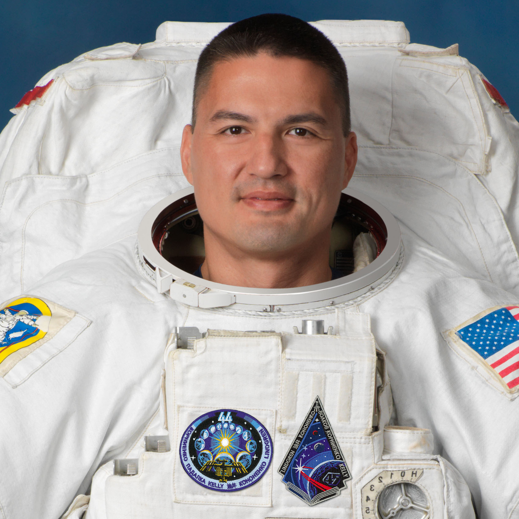 Lin Chi-er in a white NASA Extravehicular Mobility Unit (EMU), wearing helmet, gloves, and life support backpack, official portrait taken from a low angle