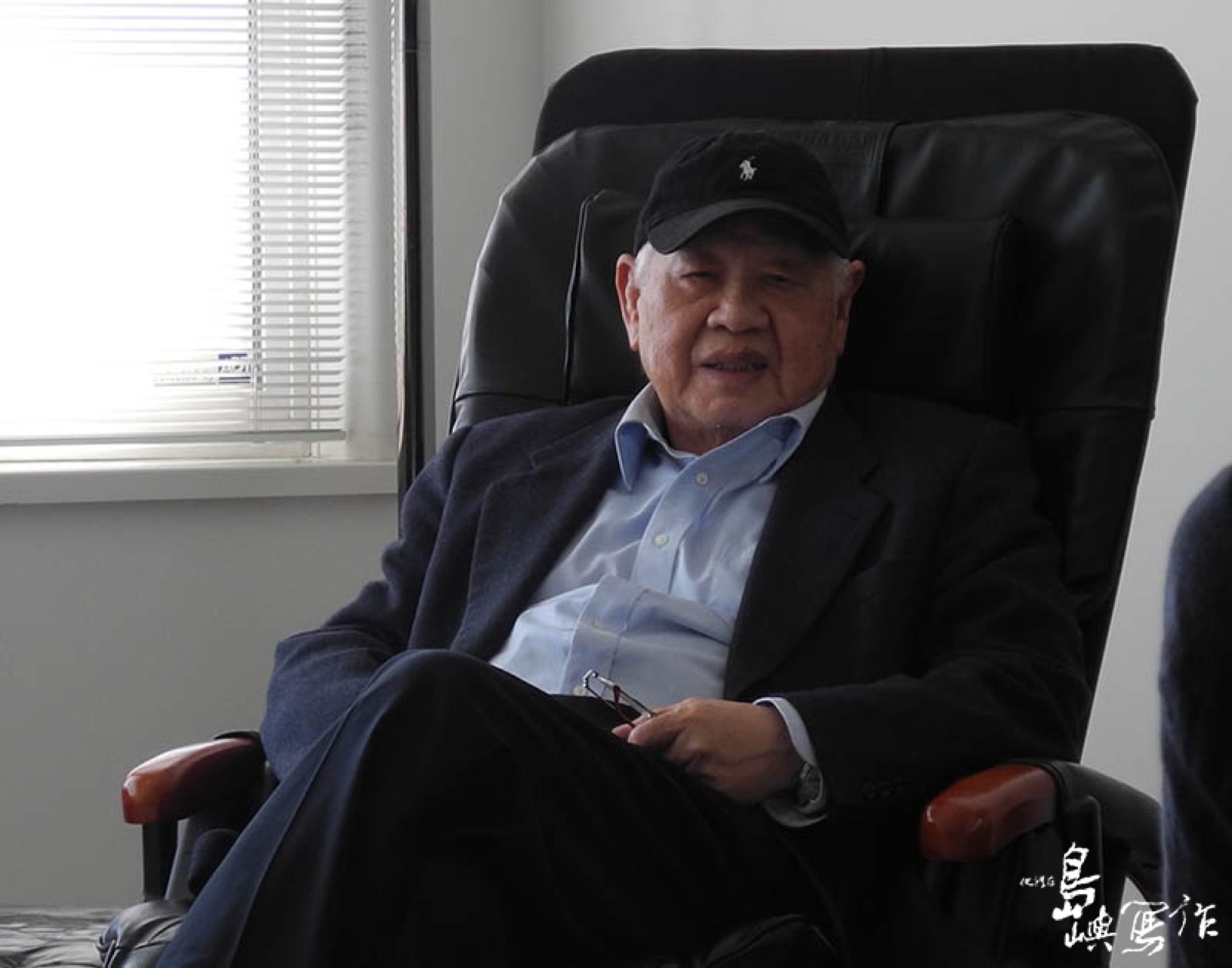 A 2012 documentary-set portrait of Luo Fu filmed by目宿媒體, an elderly man with silver hair and gold-rimmed glasses, looking intent. Luo Fu was one of the co-founders of the Genesis Poetry Society and, together with Ya Hsien and Zhang Mo, was known as part of the “iron triangle” of postwar Taiwan modern poetry.