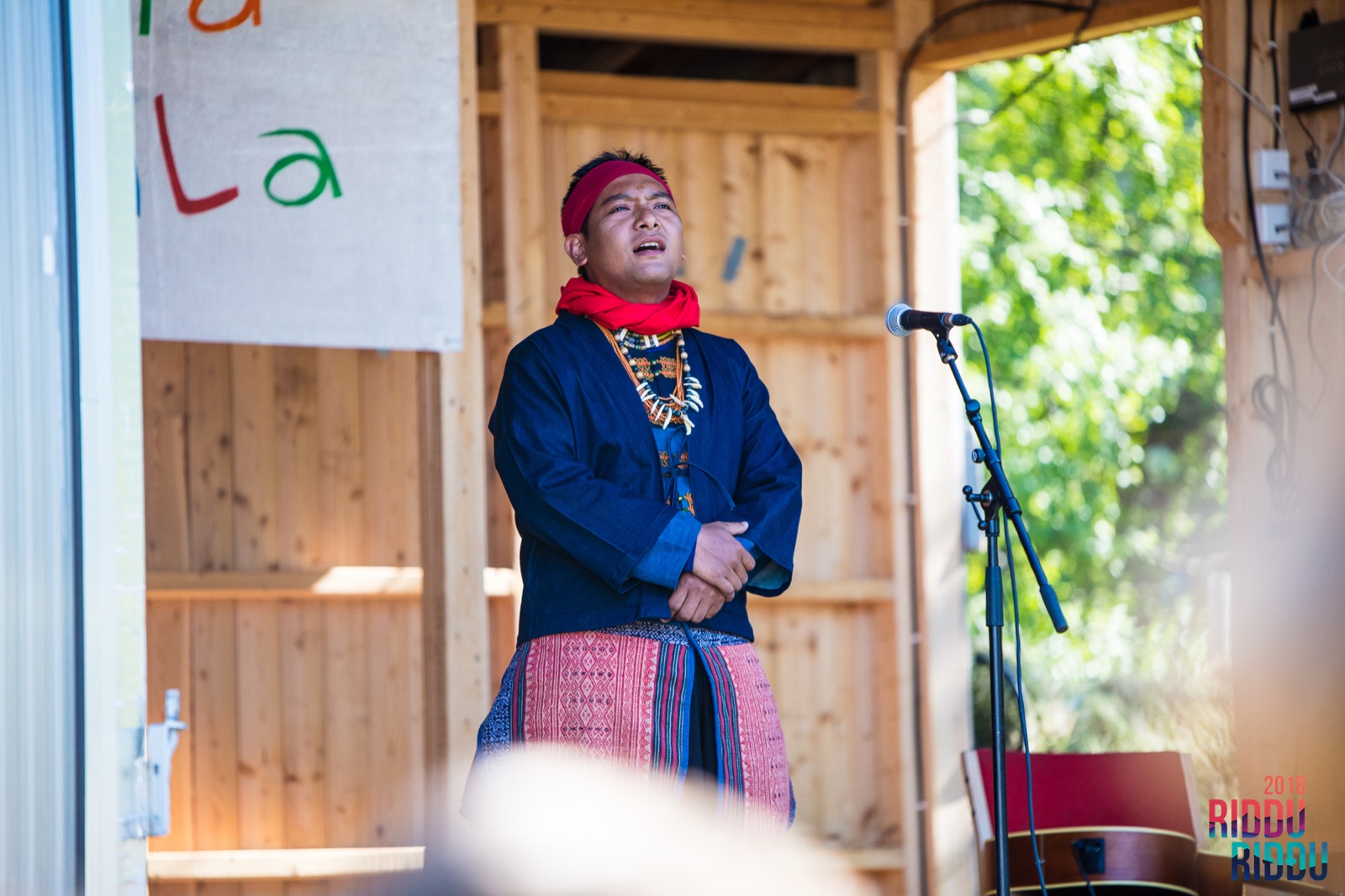 Presentación tradicional de canto y danza paiwan: tres integrantes del pueblo interpretan juntos con vestimenta tradicional. La poesía de Monaneng también surgió originalmente así en 1984: de su boca, en forma de bebida, oralidad y canto, para luego ser transcrita por otros.