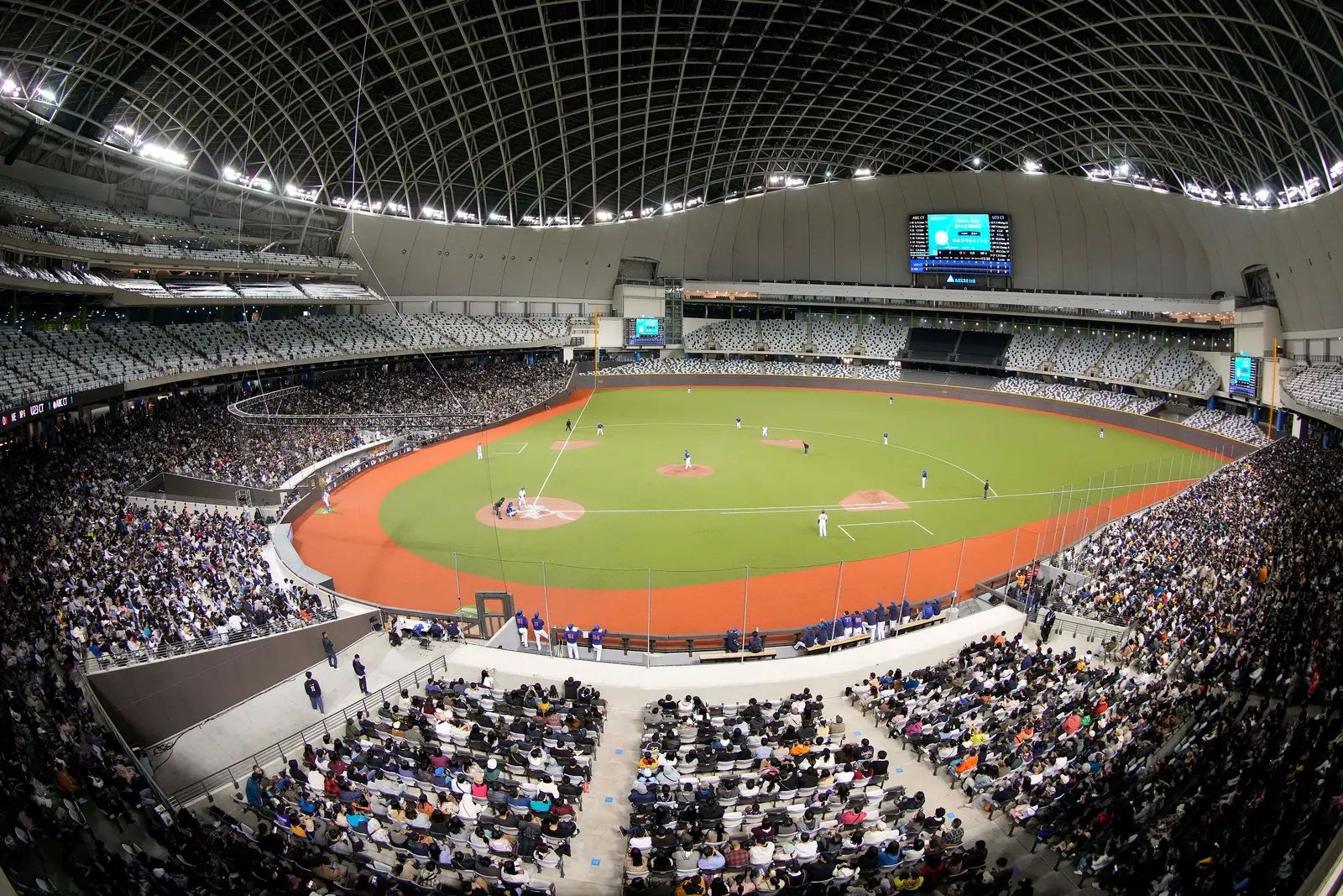 Das Innere des Taipei Dome am 18. November 2023; die unteren Tribünen sind voll besetzt, auf dem Spielfeld findet gerade ein Baseballspiel statt, das weiße Gitterdach überspannt das gesamte Stadion
