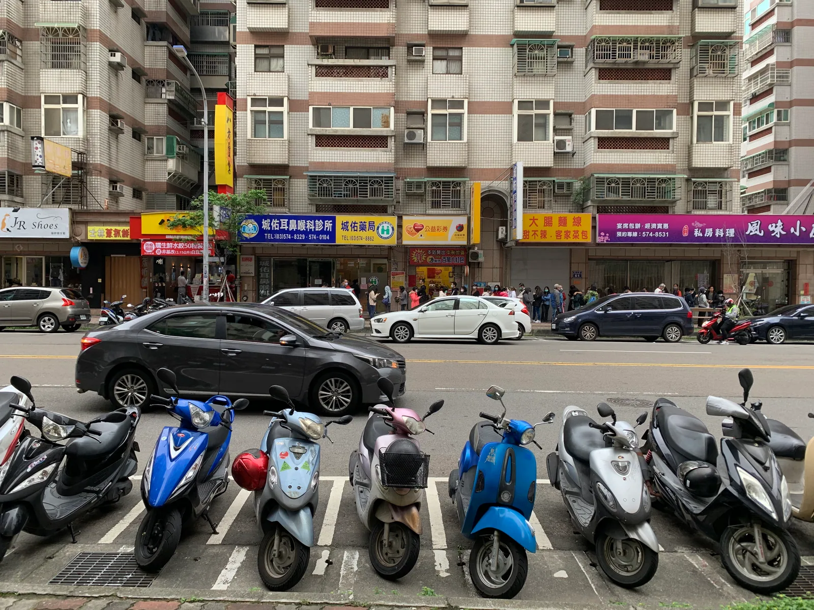 2020 年 3 月新竹市藥局外,民眾持健保卡排隊購買實名制口罩