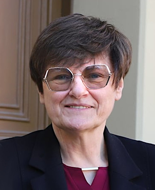 卡塔琳・卡里科 2021 年 5 月於塞格德大學(University of Szeged)公開活動,身著紅色外套站在大學徽章前