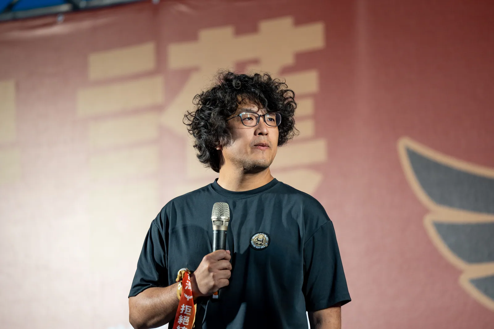 2025년 “통일전선 거부, 타이완 수호” 대회 현장의 군중. 흑곰학원의 민방위 교육은 중국의 위협에 고도로 경계하면서도 섬 안 정치에 의해 강하게 갈라지는 이런 사회 분위기 속에서 자라났다.