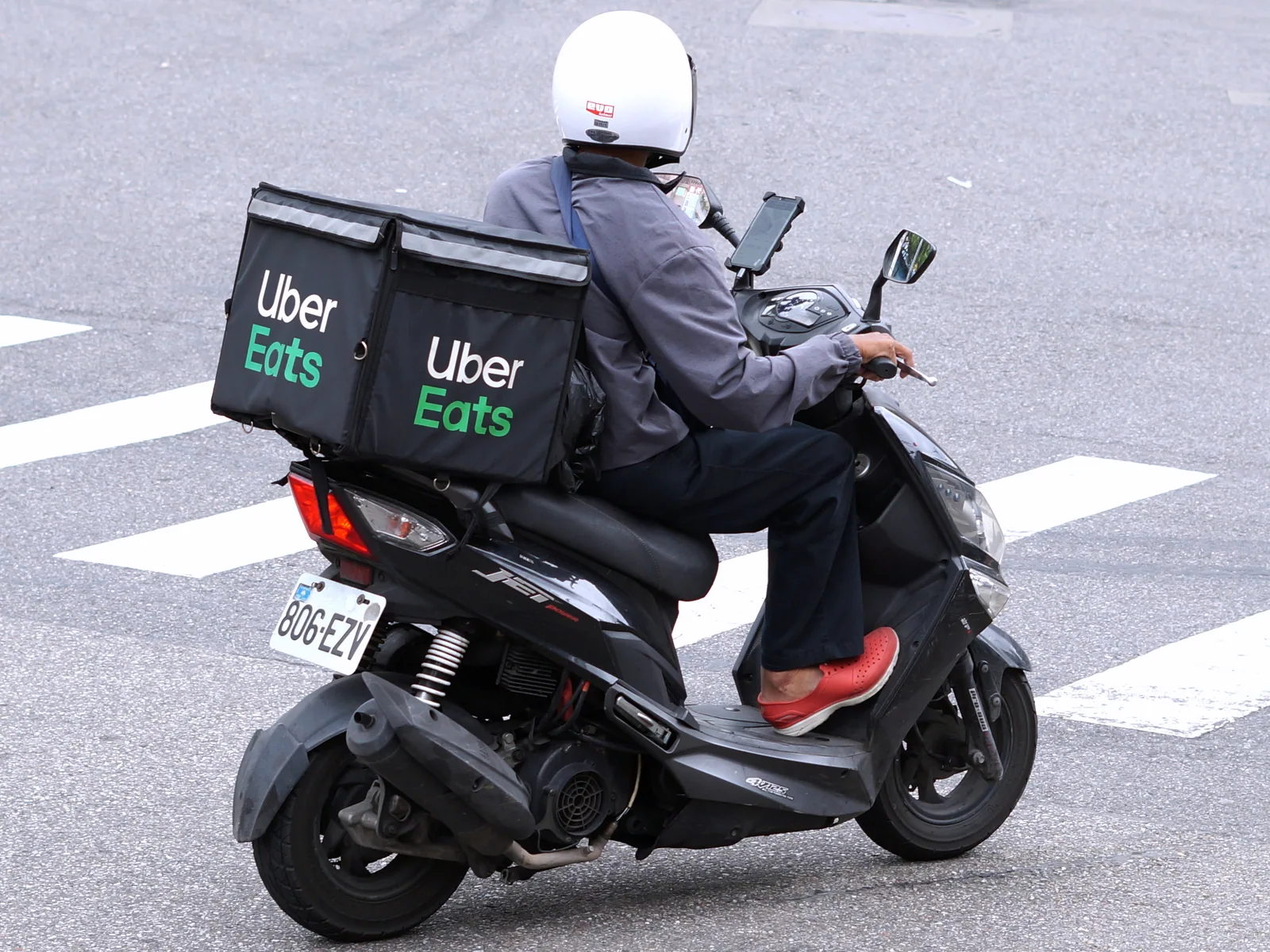 Uber Eats 外送員的機車，後座架著綠色保溫方箱