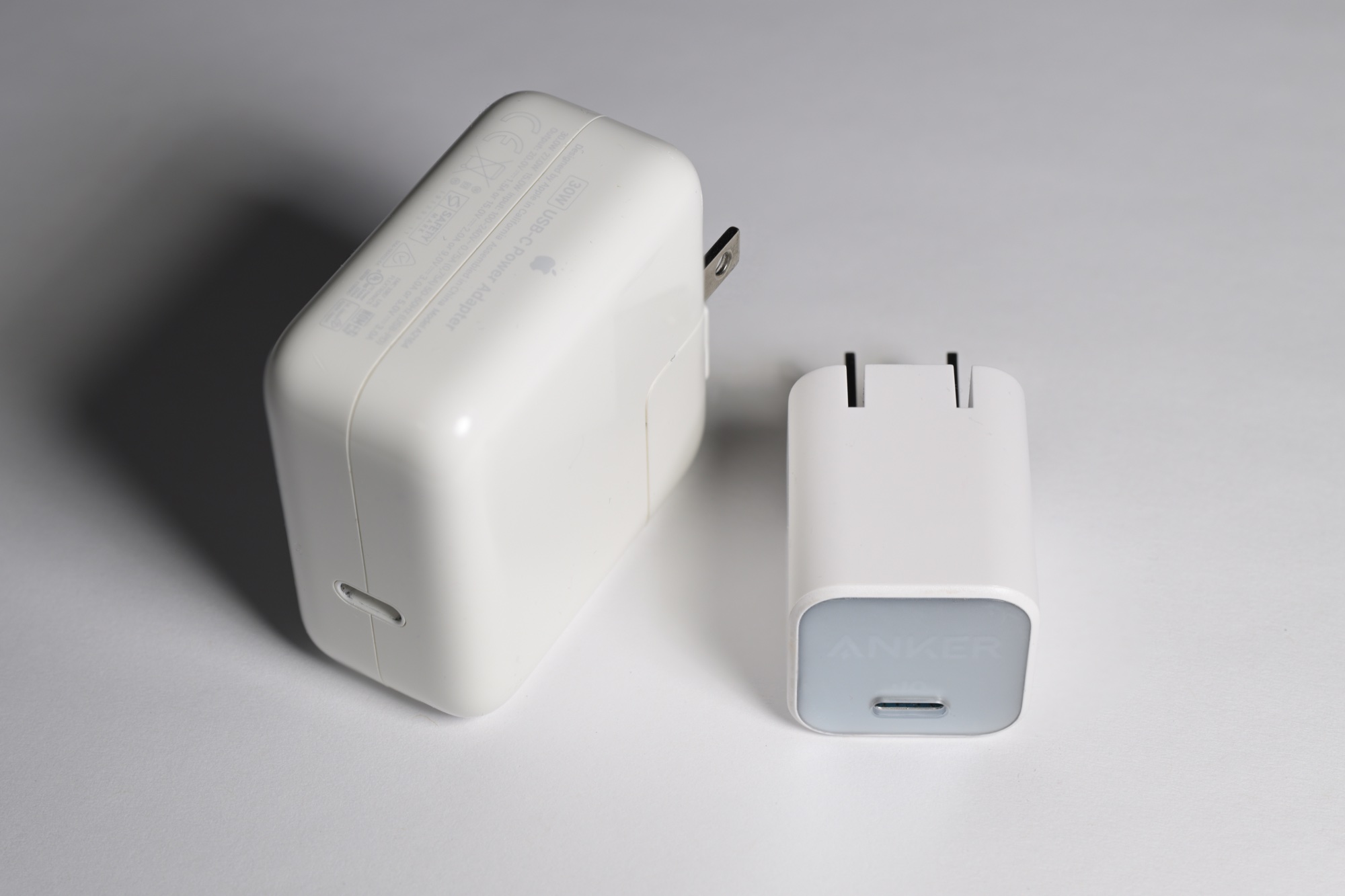 동일 출력 30W USB-C 고속 충전기 두 개를 나란히 비교한 사진. 왼쪽의 실리콘 소재 제품은 부피가 뚜렷하게 크고, 오른쪽의 질화갈륨 제품은 거의 절반 가까이 작아져 재료과학이 어떻게 에너지 밀도를 손바닥 안으로 압축하는지 보여준다