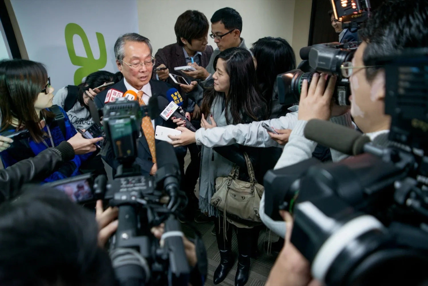 Stan Shih durante una entrevista conjunta con varios medios en el evento Taipei IT Month de 2014; viste traje oscuro, frente a él hay una fila de micrófonos y cámaras, y detrás se ve el recinto de la feria