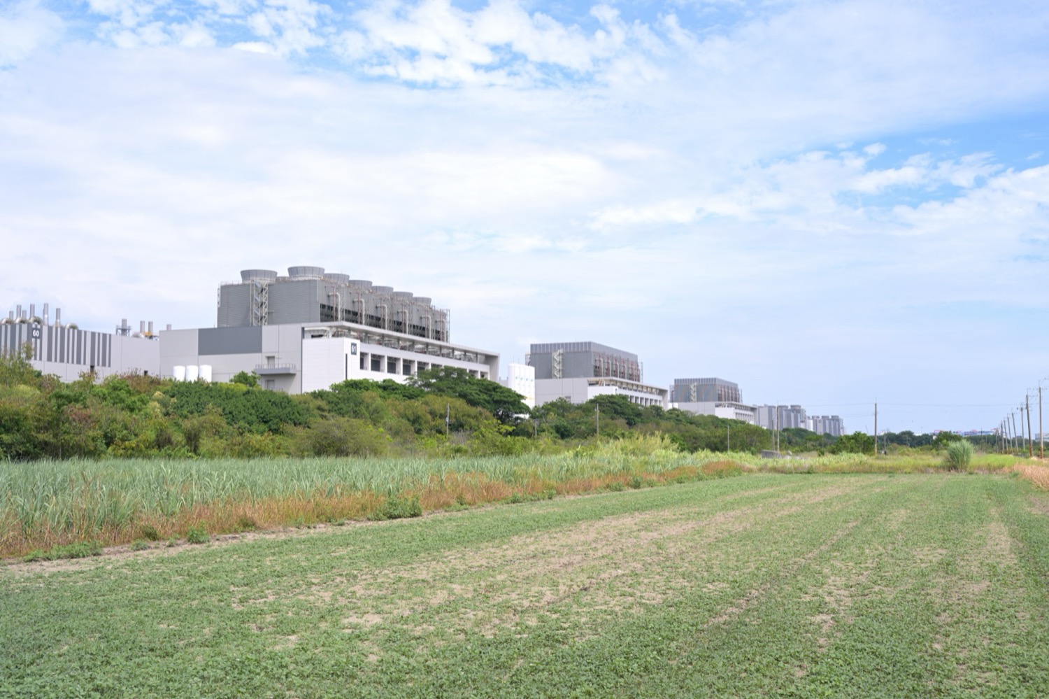 Fab 18 de TSMC en el parque de Tainan del Parque Científico del Sur, con la planta junto a tierras agrícolas: la imagen más directa de “salas limpias nacidas sobre campos de caña”