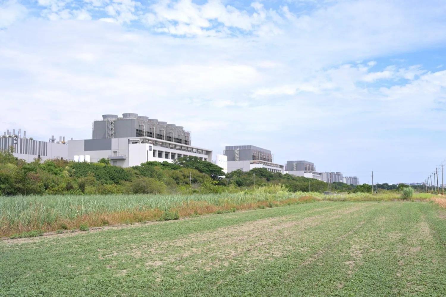 TSMC が南部科学園区台南園区に置く Fab 18。工場棟は農地に隣接しており、「サトウキビ畑の上にクリーンルームが育った」ことを最も直接に示す光景です