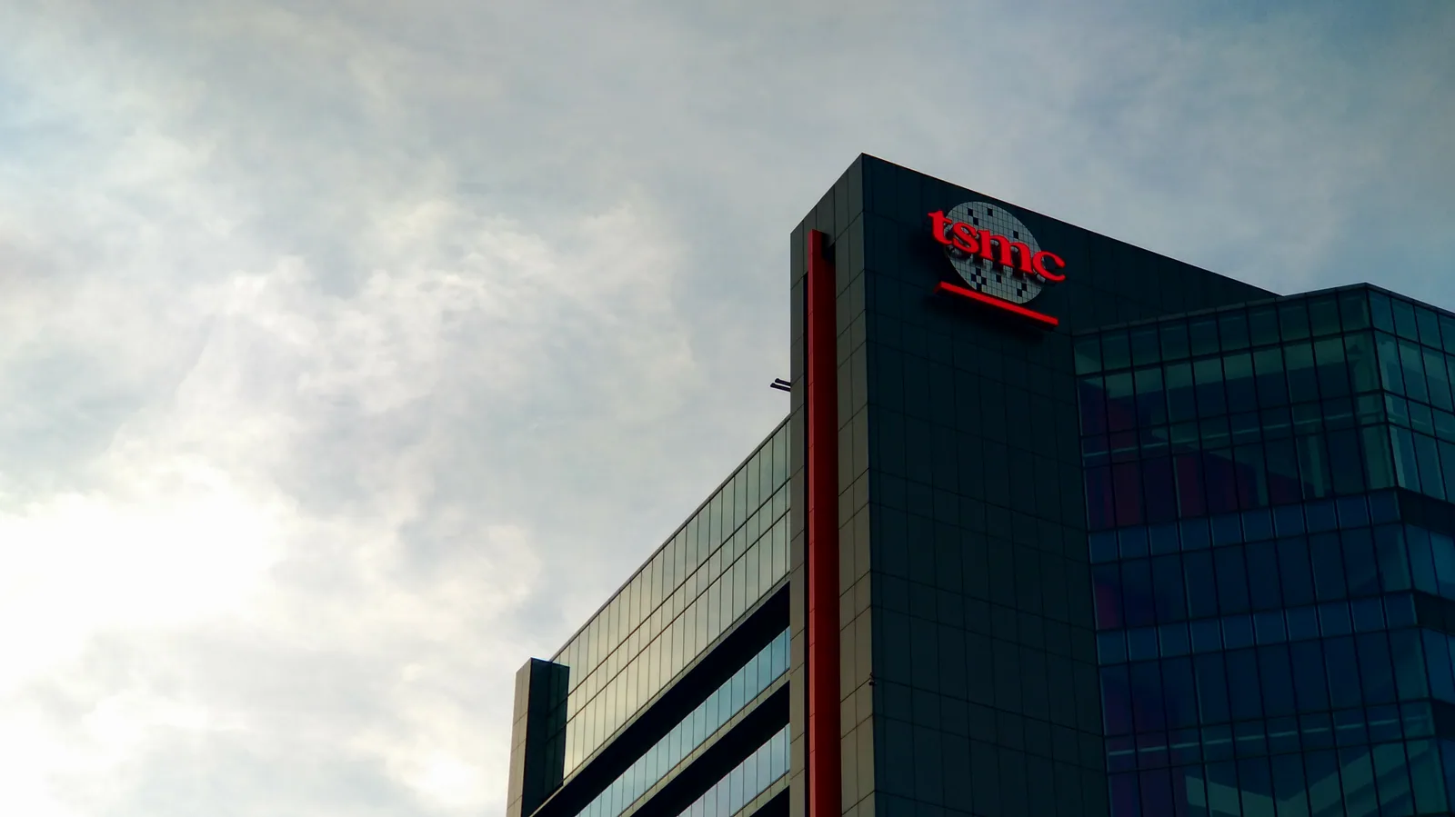 台積電台中廠房外觀，灰色建築立面掛著 TSMC 標誌